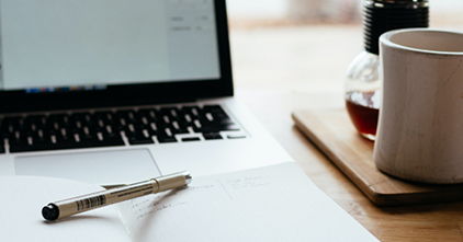 laptop with a pen and cup